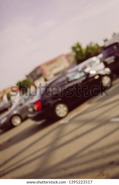 Photo of blurred\
parking cars in the city. Blur the car parked on the parking lot\
and the afternoon street. Blurred photo of Cars in the parking lot.\
vintage photo processing