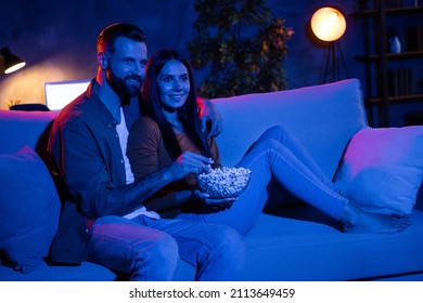 Photo of bonding spouses sit cozy couch guy hug embrace lady eat pop corn watch romance series in dark night room
