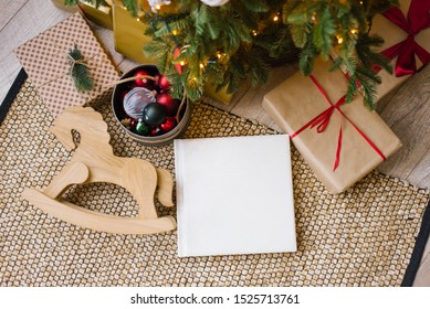 Photo Book In White Leather Cover, Wedding Or Family Photo Album Under The Christmas Tree Surrounded By Christmas Gifts