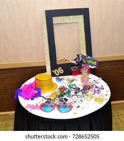 Photo Booth Prop Table With Decorations (frame,hat,glasses,beads,feather Boa And Paper Props) In Hotel For Class Reunion.