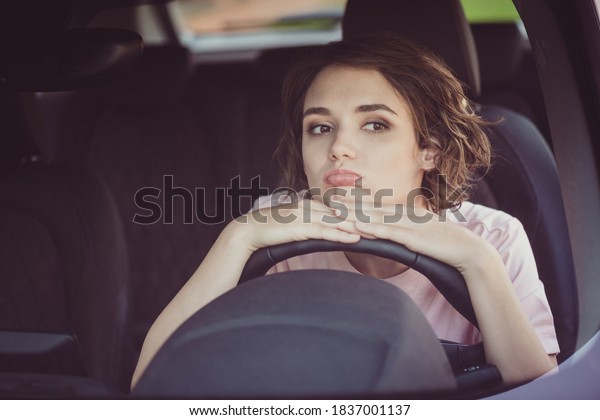 Photo of bored unhappy cute young woman lady driver\
sleepy sit put head hands steering wheel alone car drive home\
traffic jam bad news upset expression wear beige t-shirt inside\
auto salon