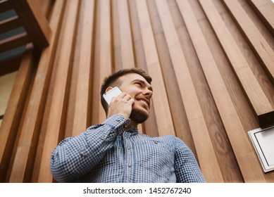 A photo from the bottom corner of a guy using his cell phone