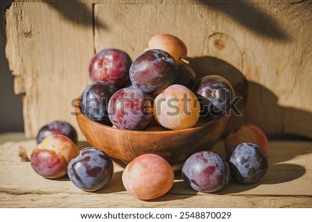 A photo of a bowl of fresh, juicy plums.