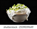 A photo of a bowl of fresh sour cream topped with vibrant green onions