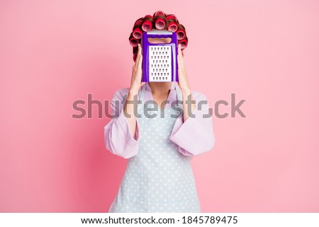 Photo of brown haired housewife hold grater cover face wear dotted apron isolated on shine pastel pink color background