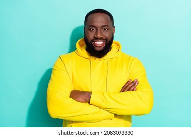 Photo of brunette cool millennial beard guy crossed arms wear yellow sports cloth isolated on teal color background