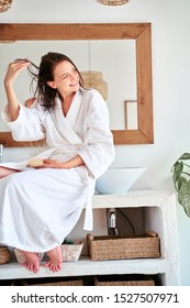 Photo Of Brunette Girl With Comb And Wet Hair Sitting In Bath.