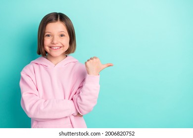 Photo of brunette hairdo small girl point empty space wear pink sportswear isolated on teal color background