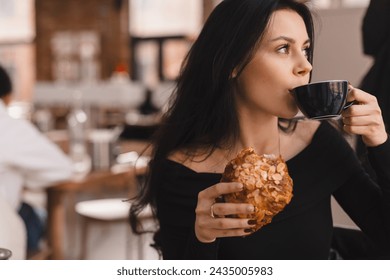 Photo of brunette teen woman ordering coffee and croissant. Young woman having breakfast with croissant and cup of coffee at the cafe. Girl drink mug of tea and hold croisant. - Powered by Shutterstock