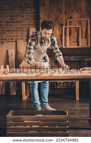 Photo of builder guy using blueprint write plan scheme in garage indoors