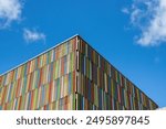 Photo of a building known as the rainbow building due to the rainbow coloured wood cladding across the building, located in the city of in Leeds in West Yorkshire on a sunny summers day