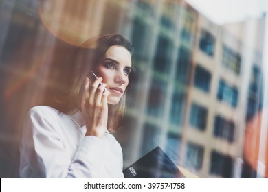 Photo Business Woman Wearing Modern White Shirt, Talking Smartphone And Holding Documents In Hands. Open Space Loft Office. Panoramic Windows Background. Horizontal Mockup. Film Effect