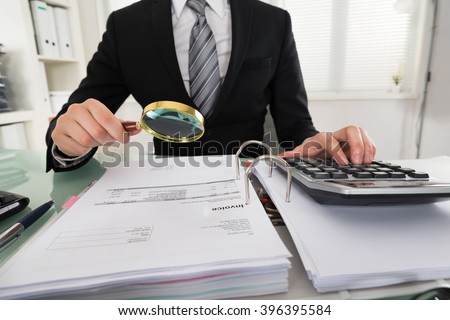 Photo Of Businessman Analyzing Bills With Magnifying Glass