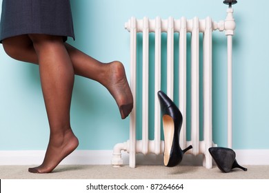 Photo Of A Businesswomans Legs With Stockings On Kicking Her High Heel Shoes Off As She Returns Home After A Hard Day At Work. Motion Blur On One Of The Shoes.