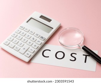 Photo of a calculator and a card labeled Cost. A picture of an image that aims to reduce costs.