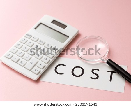 Photo of a calculator and a card labeled Cost. A picture of an image that aims to reduce costs.