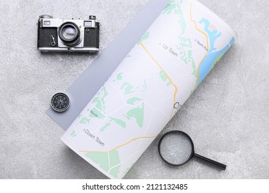 Photo Camera, Compass, Magnifying Glass And Rolled Map On Grey Background