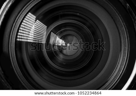 Photo Camera or Video lens close-up on black background, objective, concept of photographer camera man job, looking for a photographer, journalist, a videographer to work black and white