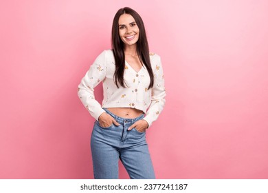 Photo of candid pretty woman brunette hair latin model posing hands put pockets her denim jeans crop top isolated on pink color background