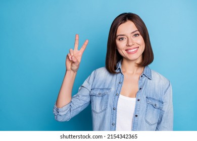 Photo of candid satisfied person hand show make v-sign toothy smile isolated on blue color background
