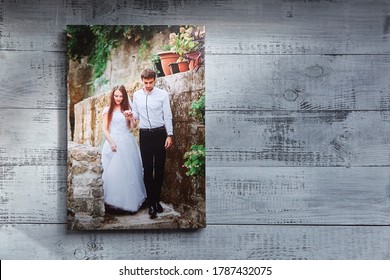 Photo Canvas Print. Sample Of Stretched Wedding Photography, Front View. Bridal Portrait Hanging On Grey Wooden Wall With Sunlight