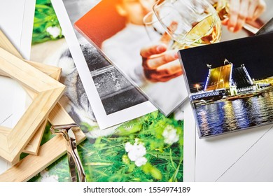 Photo Canvas Prints. Tool For Wrapping. Colorful Photographs, Pile Of Wooden Stretcher Bars And Canvas Pliers On Table. Photos Printed On Glossy Synthetic Canvas