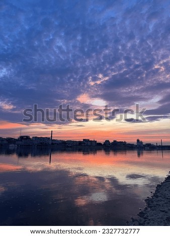 Photo captures a mesmerizing sunset in Kyiv, with the majestic Dnipro River flowing peacefully alongside the city.