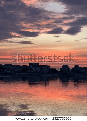 Photo captures a mesmerizing sunset in Kyiv, with the majestic Dnipro River flowing peacefully alongside the city.
