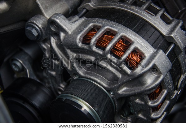 Photo of a car generator. Car parts under the hood\
of a car.