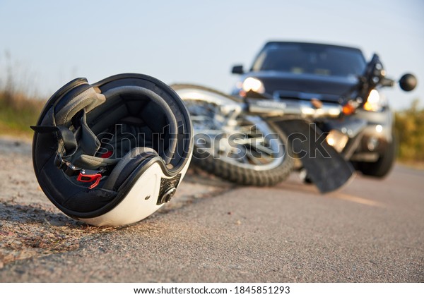 Photo of car, helmet and motorcycle on road,\
the concept of road\
accidents.