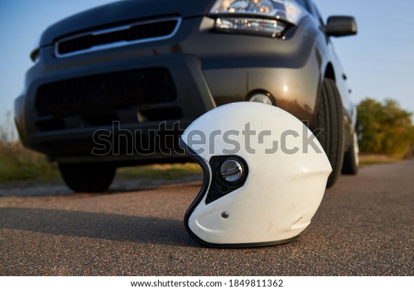 Photo of car and motorcycle helmet on the\
road, the concept of road\
accidents.