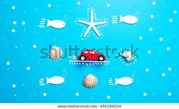 photo of car shaped toys, starfish and\
seashells on the wonderful blue studio\
background