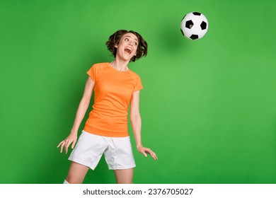 Photo of carefree astonished girl open mouth look flying ball head make shot isolated on green color background - Powered by Shutterstock