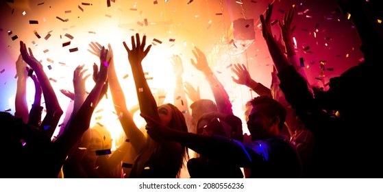 Photo of carefree clubbers blurred movement enjoy electro star performance raise hands up festival confetti modern neon filter