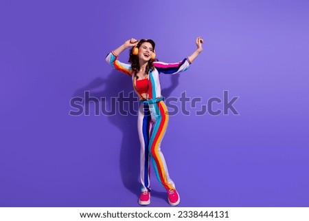 Photo of carefree lady have fun listen pop music with wireless headset isolated on violet color background