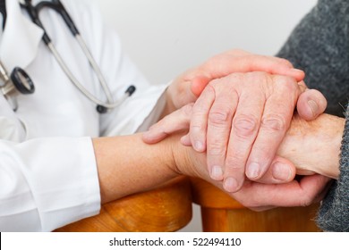 Photo of a caregiver hand touching elderly patients hand