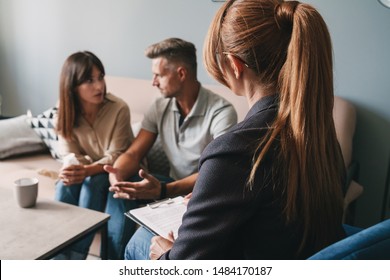Photo of caucasian casual couple man and woman having conversation with psychologist on therapy session in room