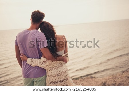 Photo of charming adorable young couple wear casual clothes hugging looking water outside countryside