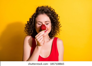 Photo of charming amazing lovely girlish funny funky wavy lady enjoy summer season fresh smell flavor berry close eyes wear red tank top isolated yellow color background
