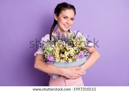 Photo of charming cheerful lady arms hold box of wild flowers toothy smile isolated on violet color background