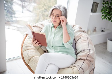 Photo of charming cheerful person sit on chair hand touch glasses reading book have good mood weekend indoors - Powered by Shutterstock