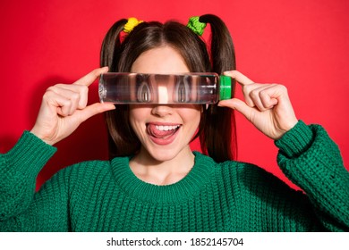 Photo of charming childish young woman dressed green knitted sweater cover eyes water bottle isolated red color background