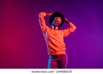 Photo charming clubber lady dance hands head rejoice wear hoodie earphones specs isolated gradient dark background
