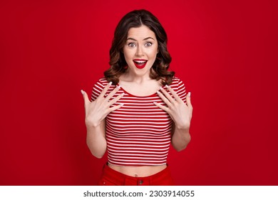 Photo of charming curly lady stunned happiness touch chest not believe she win prize isolated red maroon color background