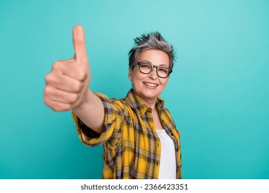 Photo of charming elderly woman showing thumb up symbol pit like social network insta post isolated teal color background