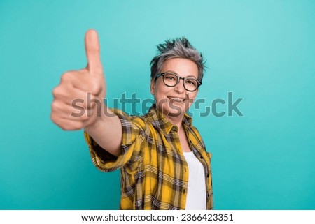 Photo of charming elderly woman showing thumb up symbol pit like social network insta post isolated teal color background
