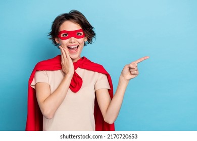 Photo Of Charming Excited Lady Dressed Red Mantle Arm Hand Cheek Cheekbone Pointing Empty Space Isolated Blue Color Background