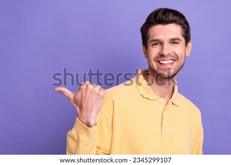 Photo of charming funky guy wear yellow shirt showing thumb empty space isolated violet color background