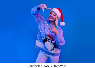 Photo of charming girl hands fingers show cadre gesture enjoy x-mas eve atmosphere isolated on blue color neon background - Powered by Shutterstock