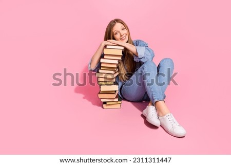 Photo of charming girl pupil wear trendy clothes sitting presenting many books bookstore empty space isolated on pink color background